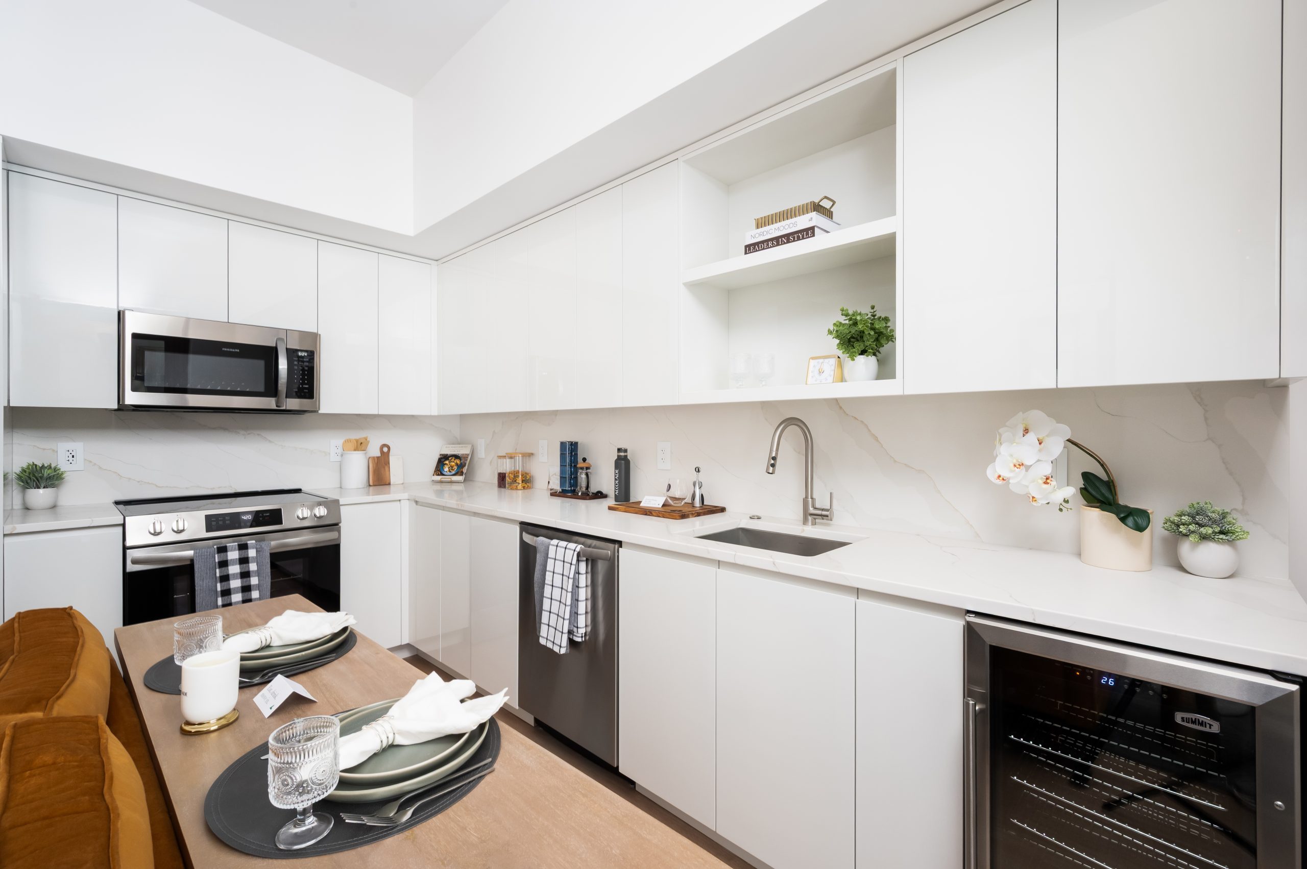 Accolade kitchen with white paneled cabinets, stainless steel appliances including a wine fridge
